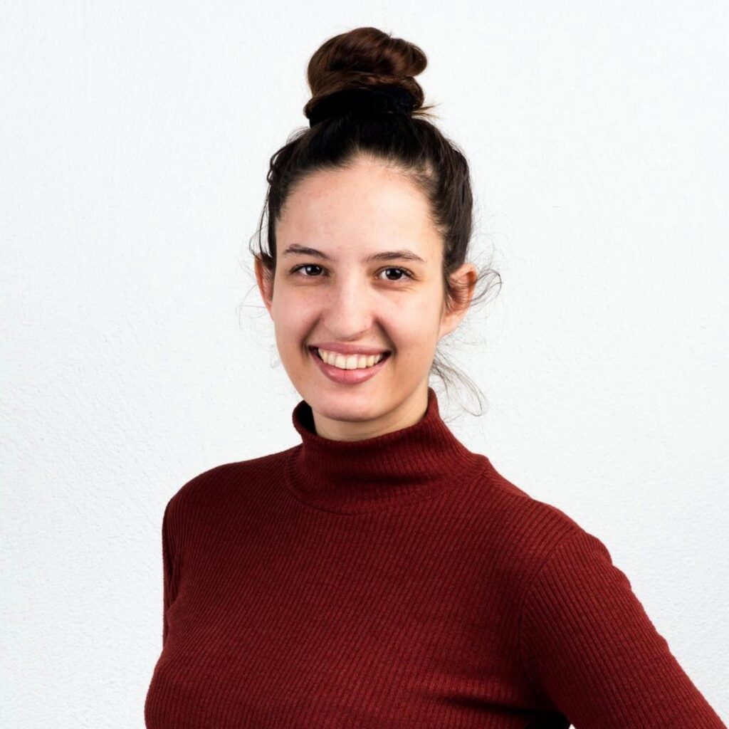 Porträt-Bild von mir – Jessica Bamford in einem bordeauxfarbenen Rollkragenpullover. Die dunkelbraunen Haare zu einem Dutt zusammengebunden.